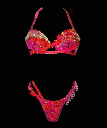 A stunning red and pink crystal bikini, ready to ship. This unique piece is inspired by the glamour of Moulin Rouge, featuring draped crystal accents that add a touch of theatrical sparkle. Carefully handcrafted in Ibiza, this one-off design ensures you’ll shine on stage.